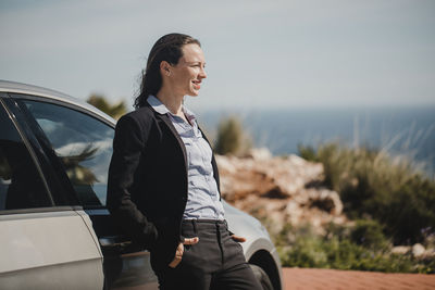 Woman looking at camera against sky