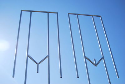 Low angle view of metallic structure against clear blue sky