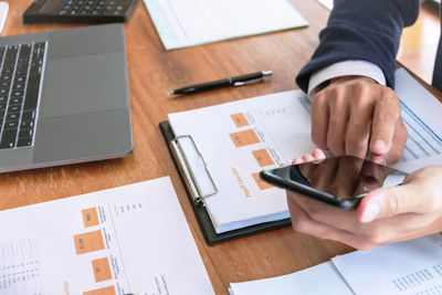 Midsection of man using laptop on table