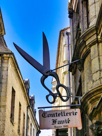 Low angle view of sign and buildings against sky