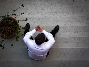 Rear view of woman sitting on wall