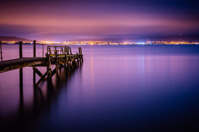 Pier on lake against sky during sunset