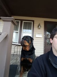 Close-up of man with dog standing in window