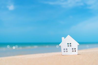 House on beach by sea against sky