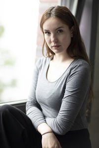 Portrait of young woman sitting at home