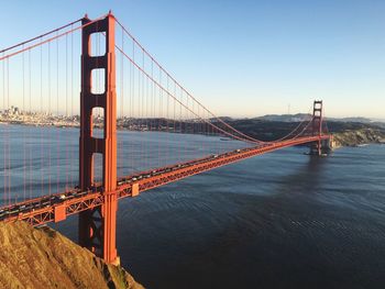 Golden gate bridge over river against sky in city