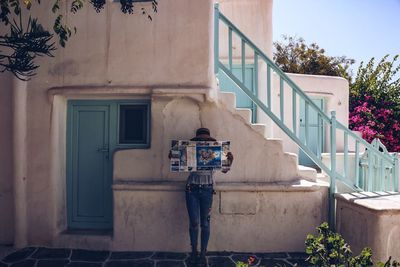 Man standing by window of building