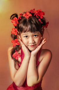 Portrait of smiling girl with red flower