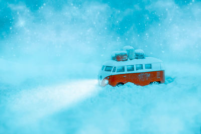 Red car in snow against blue sky