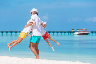 Low angle view of child on beach against sky