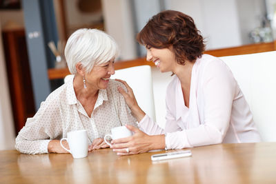 Happy senior woman with daughter at home