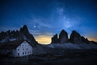 Scenic view of snowcapped mountains against sky at night