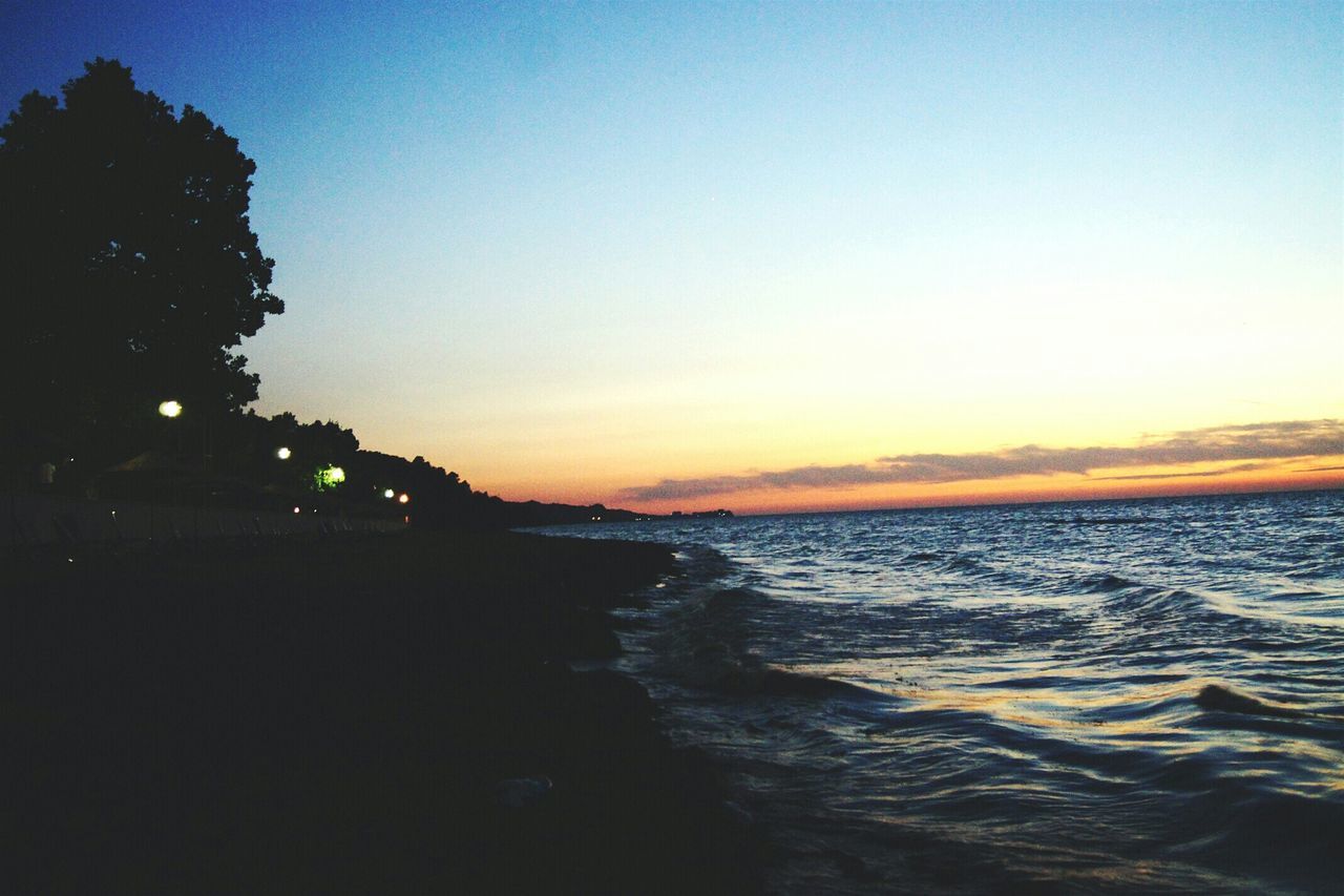 water, sunset, scenics, sea, tranquil scene, beauty in nature, tranquility, copy space, nature, sky, silhouette, waterfront, idyllic, clear sky, dusk, horizon over water, orange color, outdoors, reflection, non-urban scene