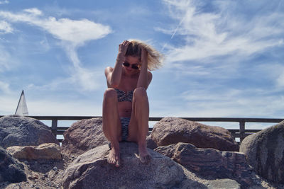 Young woman looking at sea shore against sky