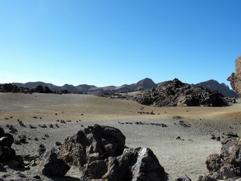 Scenic view of volcanic landscape against blue sky