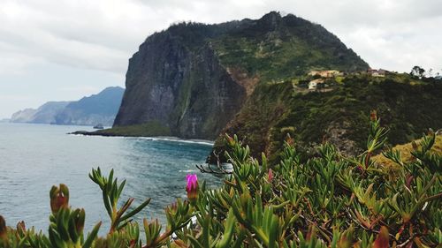 Scenic view of sea and mountains against sky