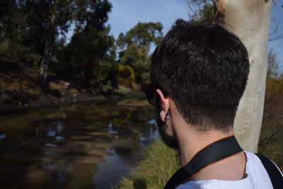 Man looking at lake against trees