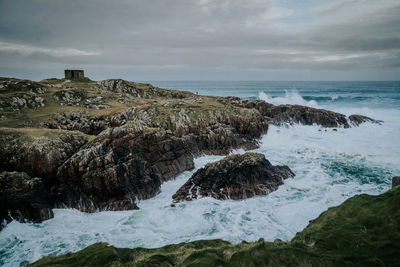 Scenic view of rocks in sea against sky