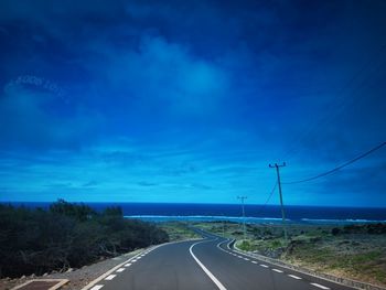 Empty road against blue sky