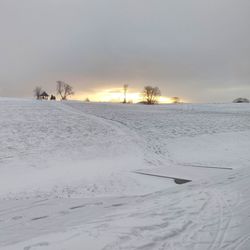 Scenic view of snow covered field against sky