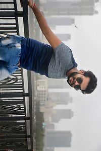 Portrait of young man standing against railing