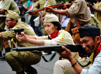 Police force aiming guns on road