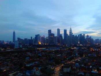 Aerial view of buildings in city against cloudy sky