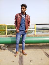 Full length of man standing by pipe against sky