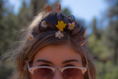 Close-up of woman wearing sunglasses and flowers
