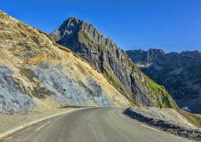 Road amidst mountains against clear sky