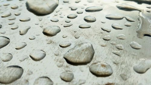 High angle view of raindrops on pebbles