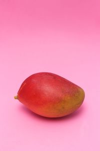 Close-up of apple against pink background