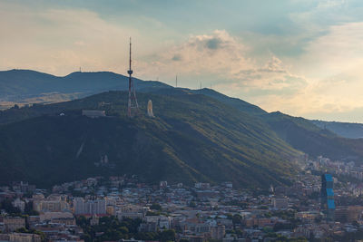 Town by mountain against sky