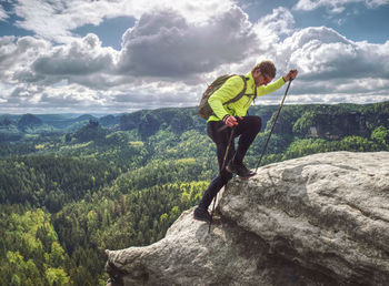 Man backpacker running up on mountain top cliff edge. travel and trail lifestyle concept adventure