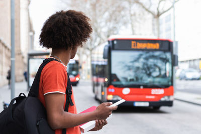 Woman using mobile phone on street in city