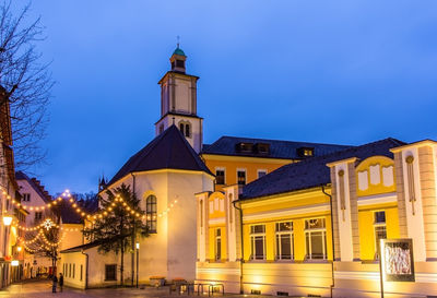 Low angle view of illuminated building against sky at dusk