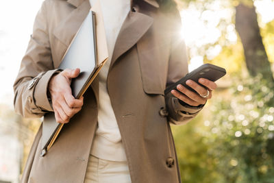 Midsection of businessman using mobile phone
