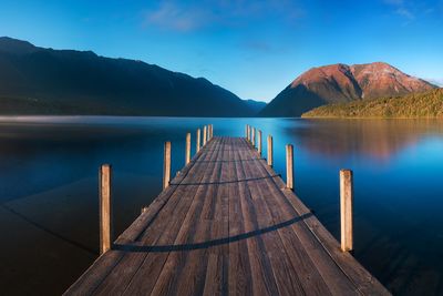 Pier over lake against mountains