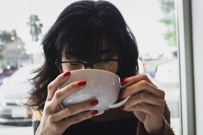 Close-up of human hand holding coffee cup