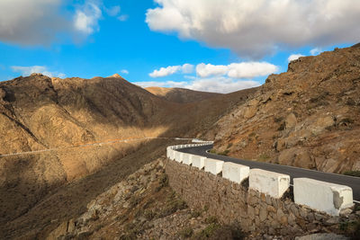 Scenic view of dam and mountains against sky