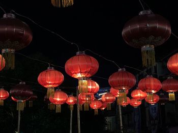 Low angle view of illuminated lanterns hanging at night