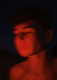 Close-up portrait of young man against black background