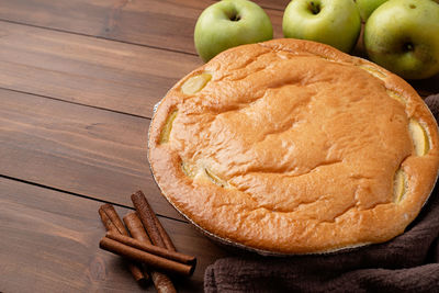 Traditional charlotte apple pie charlotte on wooden table with fresh apple and cinnamon