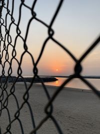 Close-up of chainlink fence and sunrise 