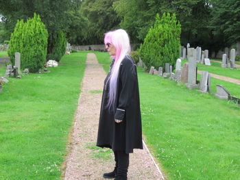 Full length of senior woman standing at cemetery