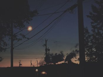 Silhouette of electricity pylon against the sky