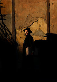 Young woman standing against wall