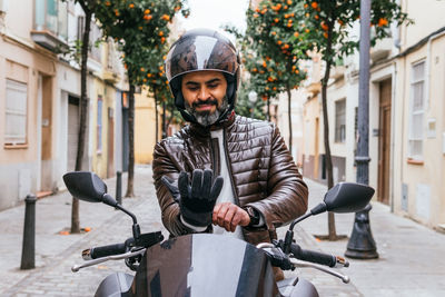 Portrait of man riding bicycle on street in city