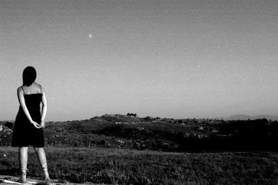 Rear view of woman standing on field