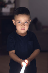 Portrait of cute boy holding lightning equipment